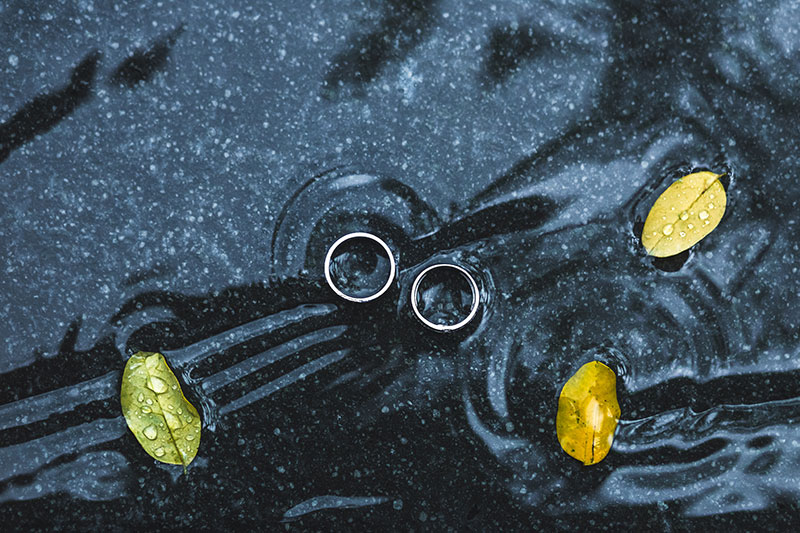anillos de matrimonio bajo la lluvia en un charco